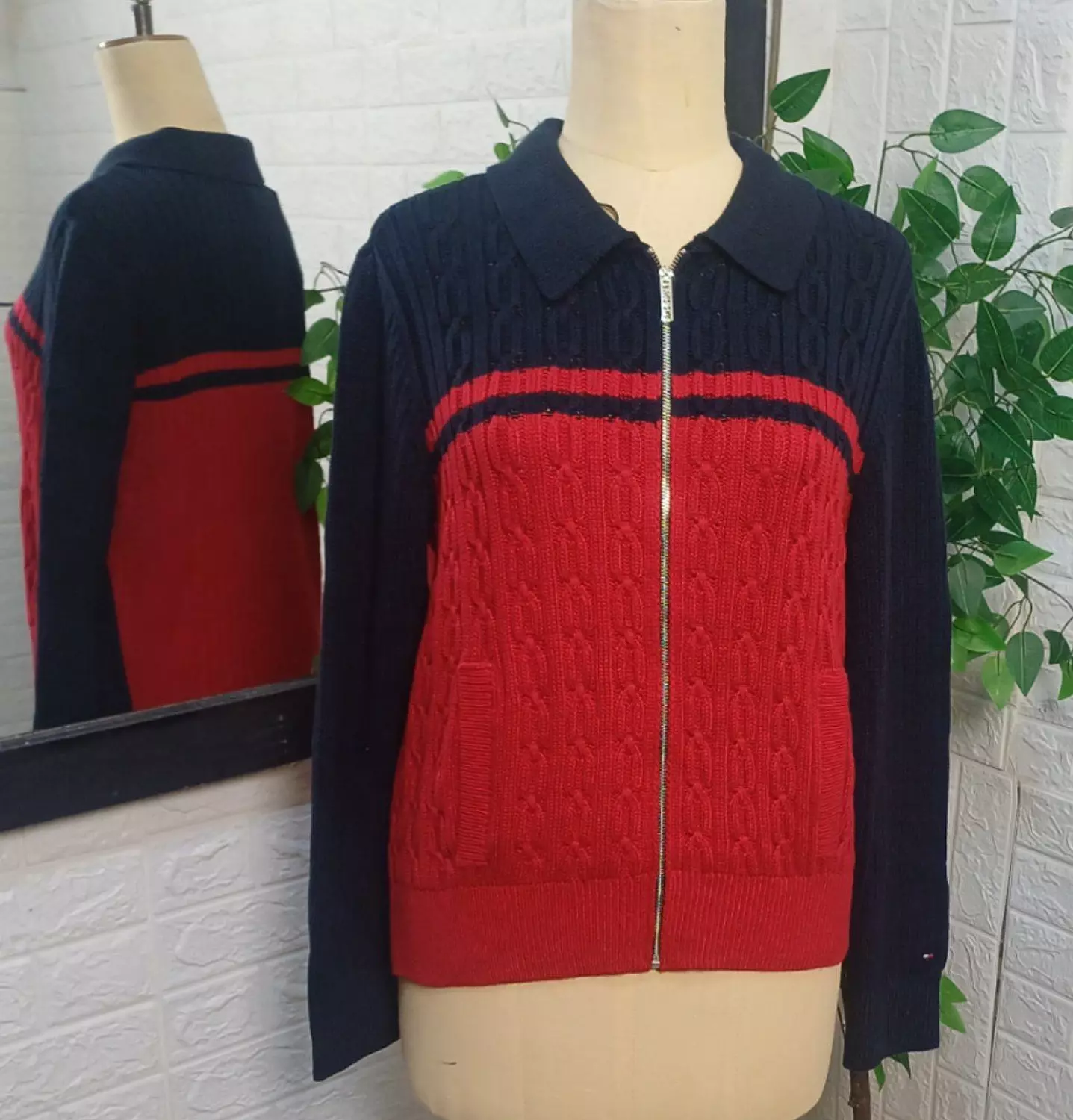 zip-up sweater/cardigan featuring a cable-knit pattern on the body.